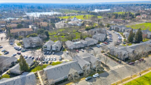Aerial Exterior of Renwick Square, surrounding communities in the background, body of water in the distance, photo taken on a sunny day.