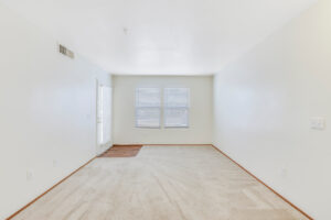 Interior Unit Living Room, Neutral toned carpeting, white walls.